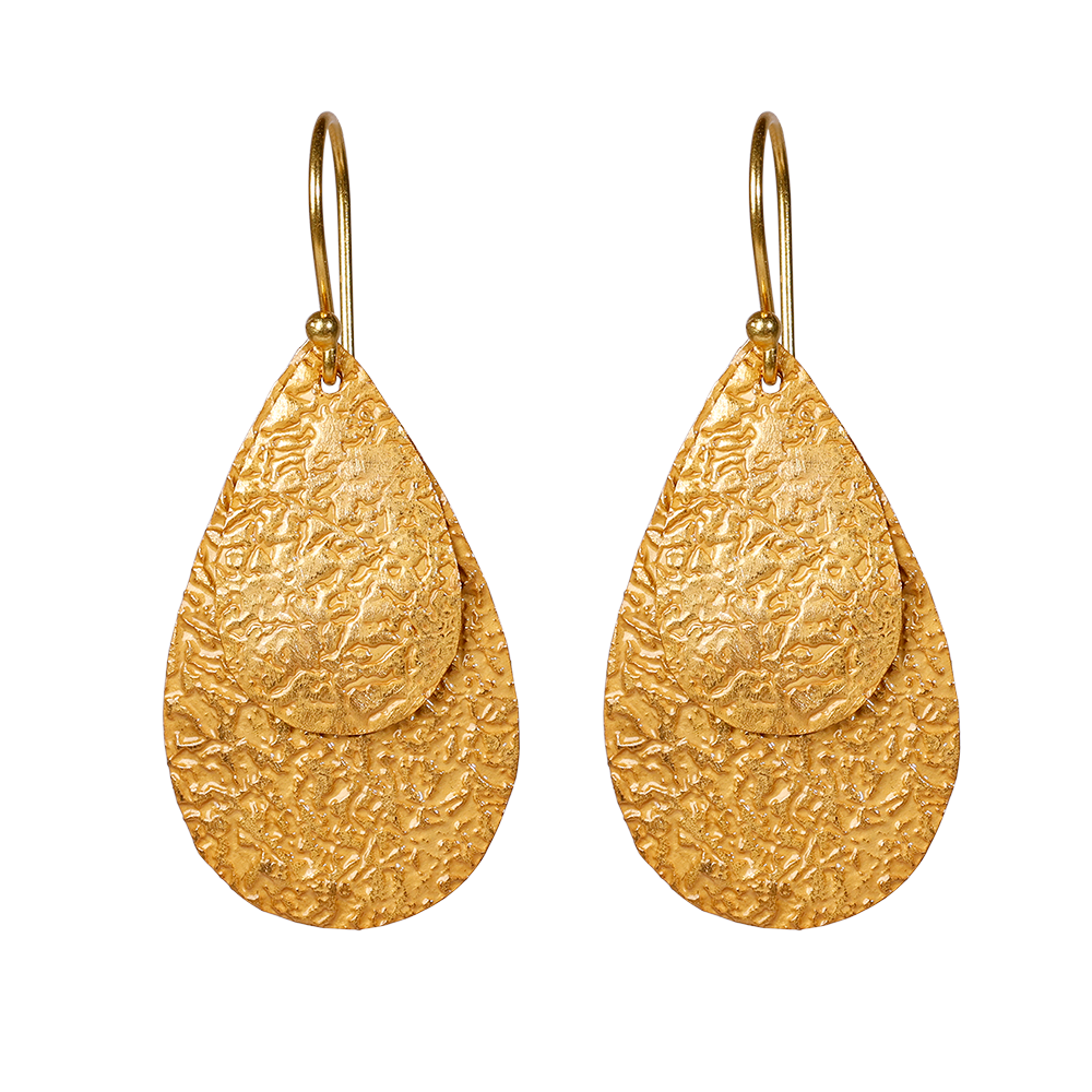Queen Pear er et sæt flotte øreringe i 24kt. forgyldt sterlingsølv med flade vedhæng i let banket overflade, der giver øreringene en flot struktur og en rå kant. Øreringene er lette at bære og er perfekt til en aften i byen, eller hvis hverdags-outfittet