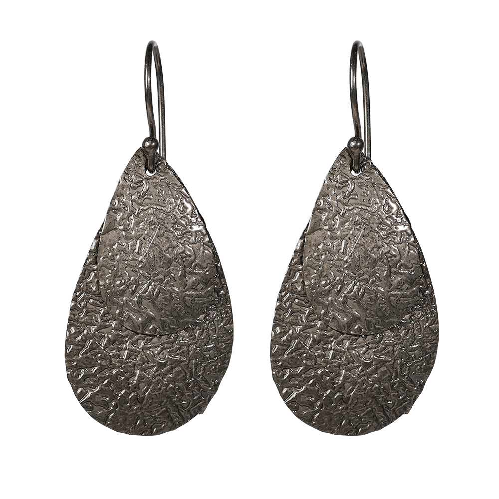 Queen Pear er et sæt flotte øreringe i sort sterlingsølv med flade vedhæng i let banket overflade, der giver øreringene en flot struktur og en rå kant. Øreringene er lette at bære og er perfekt til en aften i byen, eller hvis hverdags-outfittet skal pifte